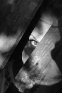 things you tell yourself, Amplify Your Message, Attract Clients, & Create Lasting Impact with Podcasts grayscale photo of woman peeking on planks - fear - the things you tell yourself