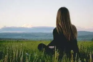 find your purpose as a woman, Amplify Your Message, Attract Clients, & Create Lasting Impact with Podcasts woman wearing black long sleeved shirt sitting on green grass field