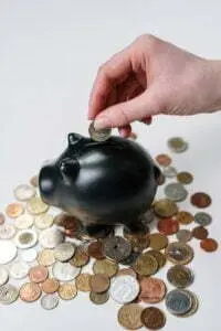 midlife women, Amplify Your Message, Attract Clients, & Create Lasting Impact with Podcasts person putting coin in a piggy bank