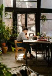 midlife women, Amplify Your Message, Attract Clients, & Create Lasting Impact with Podcasts photo of woman sitting by the table while writing